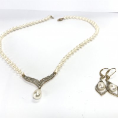 A pair of 14k gold pearl earrings and a conforming 14k gold pearl necklace.