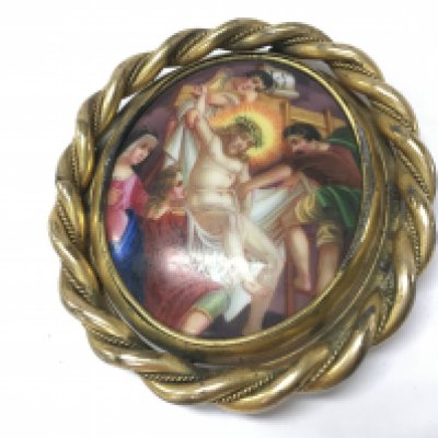 A porcelain hand painted Religious brooch depicting Jesus being taken down from the cross.