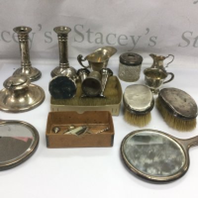 A collection of ilver items comprising a pair of candlesticks, two hand mirrors, capstan inkwell etc. Shipping category D.