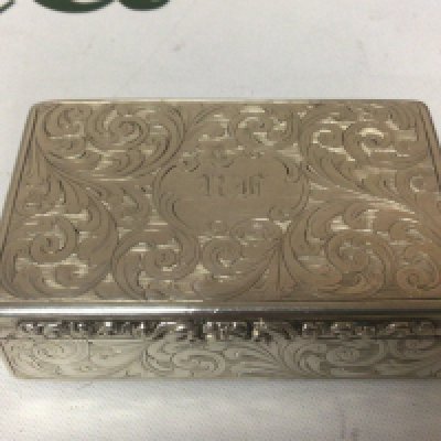 A Victorian Silver snuff box of rectangular shape with elaborate scroll decoration parcel gilt interior makers mark ES Birmingham hallmarks. 7cmx4.5cm