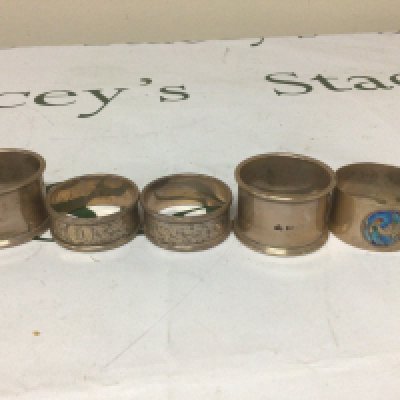 A collection of five silver napkin rings one decorated with applied enamel. Weight 146g