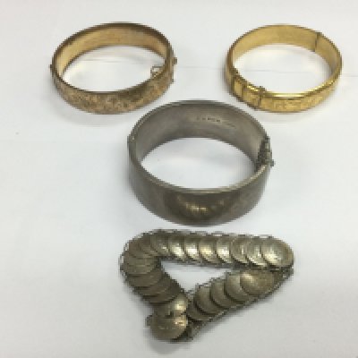Two gold plated bangles, a silver bangle and a coin bracelet. Shipping category A.