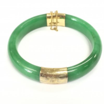 A jade bangle with 14ct gold. Approx 7cm diameter.Postage B