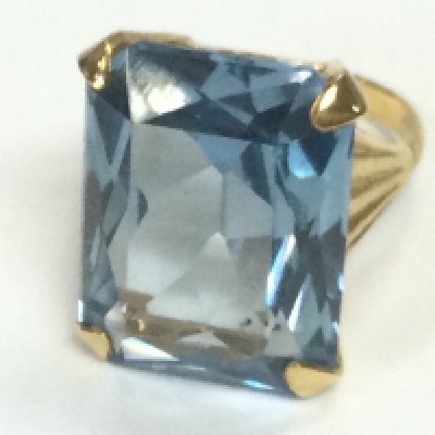A 9ct gold cocktail ring set with blue stone. K 1/2 and 8.90g Postage B