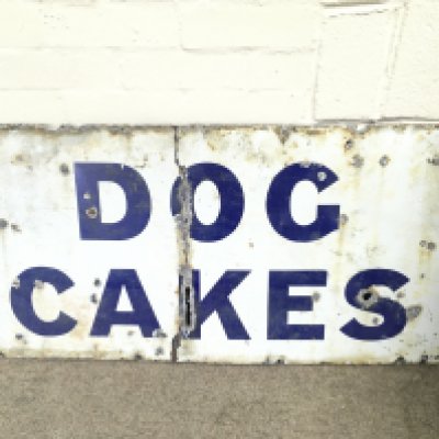 A vintage dog cakes enamel sign.40 x 20 inches approximately