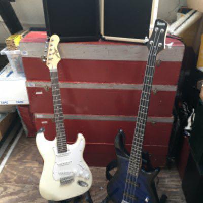 A Johnny Brook Strat style electric guitar, a Benson bass guitar and two practice amps.