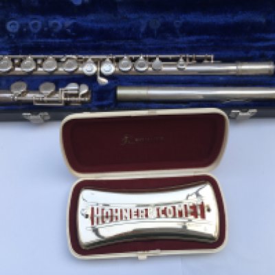 A cased flute and a cased Hohner Comet harmonica (2).