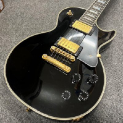 A 1999 Gibson Les Paul Custom electric guitar in Black with Gold Plated parts. Comes with original Gibson Brown Case. In good condition overall consistent with age and use on a vintage Gibson Les Paul Custom. Light fretwear and some light scratches but no edge wear, chips or cracks. This is an all original guitar with no evidence of repair or refinishing and has been backlighted. Weight 10.2lbs