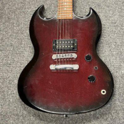 A 1998 Gibson SG X electric guitar in Cherry burst with single hum bucker pickup. In fair condition with some delimitation to the headstock front, extensive fretwear and playwear and scratches to paintwork