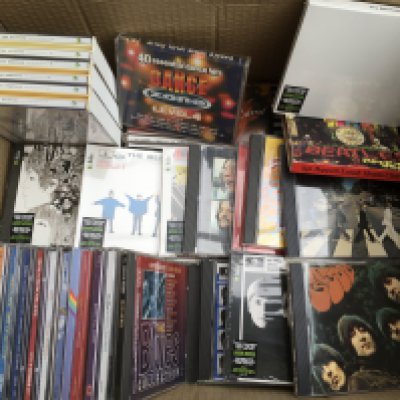 A box of CDs by various artists including The Beatles, Marc Bolan, REM and many more.