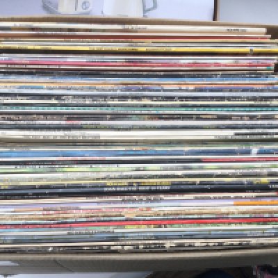 A box of LPs and 12" singles by various artists including Hawkwind, Iron Maiden, AC/DC and others.