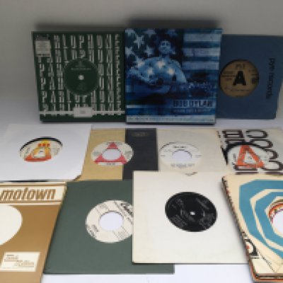 A collection of promo discs, a Pink Floyd 7" single of 'Arnold Layne', a Bob Dylan 7" singles box set, a sealed RSD 7" singles box set and some record company sleeves.