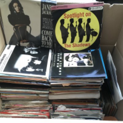 A box of 7" singles and EPs by various artists including Queen, The Damned, David Bowie and many more.