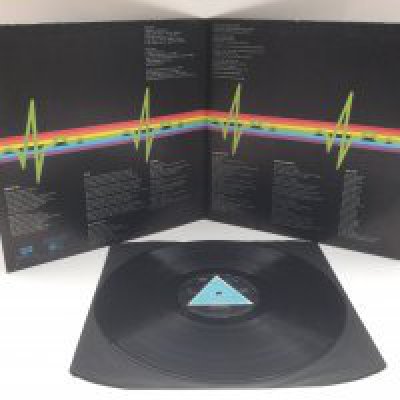 A first UK pressing of 'Dark Side Of The Moon' by Pink Floyd with solid blue triangle on labels. SHVL 804. Complete with inserts. No visible scratches. Wear to the label. Ringwear to sleeve and bumped and worn edges.
