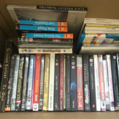 A box of music DVDs, CD box sets and books by various artists including The Beatles, Elvis Presley, Elton John and others.