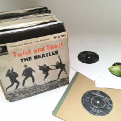 A box of Beatles and related 7" singles and EPs.