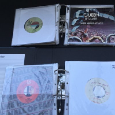 A box containing four binders of Queen 7" singles comprising US pressings and promos and a test pressing of 'Play The Game'