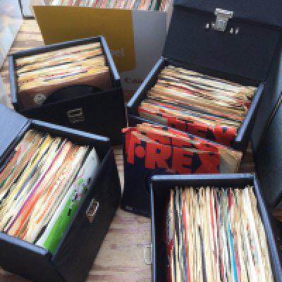 Four record cases and a box of 7" singles by various artists from the 1960s onwards including The Beatles, T Rex, David Bowie, Led Zeppelin and many more (5).