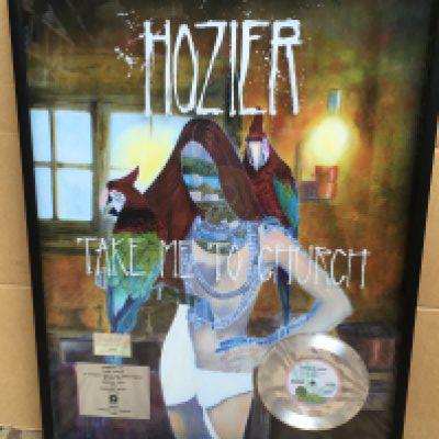 A framed and glazed Hozier silver disc display for sales of more than 1,000,000 copies and 33,000,000 streams of the single 'Take Me To Church', Island Records 2015, approx 57.5cm x 75.5cm.