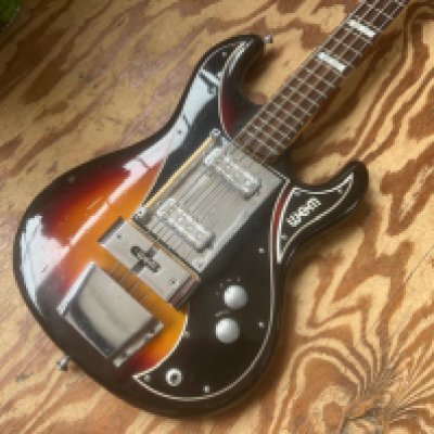 A 1965 Wem Sapphire Bass Guitar in all original condition with original wooden dowling thumb rest. Some playwear and marking to body consistent with age and use. Otherwise very good overall condition - medium to light fretwear. A classic vintage 1960's Bass Guitar. Comes with flight type case.