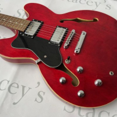 A Tanglewood TH502 Semi Acoustic Electric Guitar in Transparent Cherry Red. In very good + condition with little evidence of playwear. Little or no fret-wear, no marking and no tarnishing to brightwork.