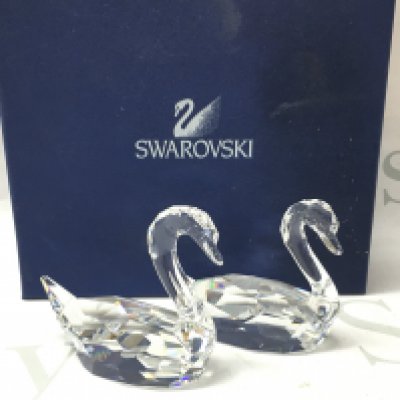 A boxed pair of Swarovski cut crystal glass swan figures. This lot cannot be posted. NO RESERVE