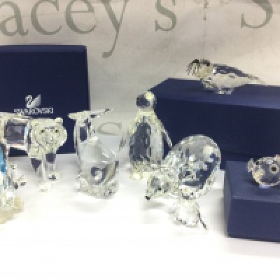 A collection of Swarovski crystal glass figures including Blue Tang fish, Tiger, Polar bear, Seal etc. some boxed . This lot cannot be posted