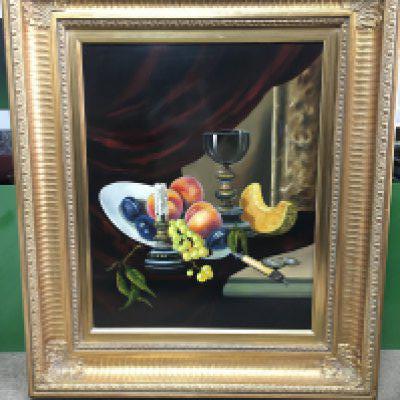 A 20th century gilt framed still life oil painting by T Gabris, depicting fruits and a goblet. Frame dimensions 61x70cm