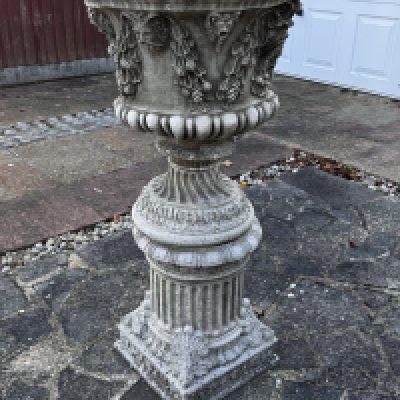A large cast concrete planter with grape vine design.- NO RESERVE