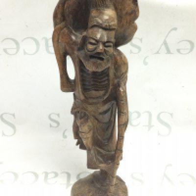 An unusual carved wooden figure with stick 43cm tall approximately . Postage category c