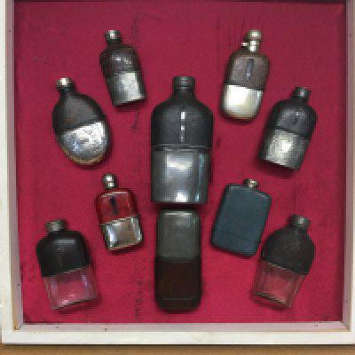 a good mounted and framed collection of ten Victorian and vintage hipflasks . This lot cannot be posted
