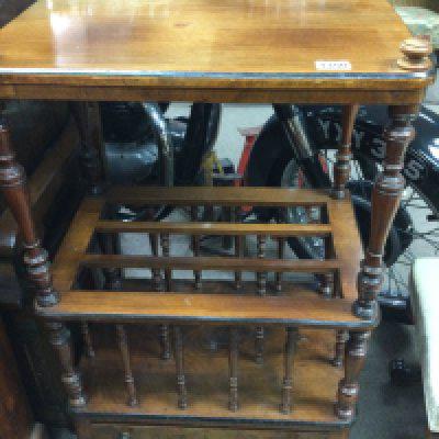 A Victorian walnut Canterbury with three open sections fitted with a single Drawer .