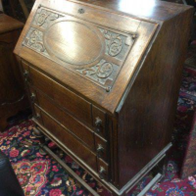 An oak bureau with decorative front panel, approx 73cm x 102cm x 42cm. Shipping category D.
