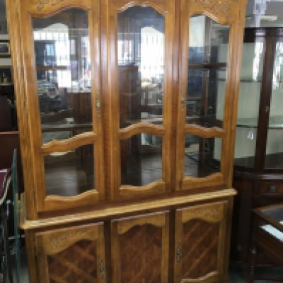 A light wood display cabinet with glazed doors above cupboards with glass shelves 202cm high width 135cm. (No reserve).