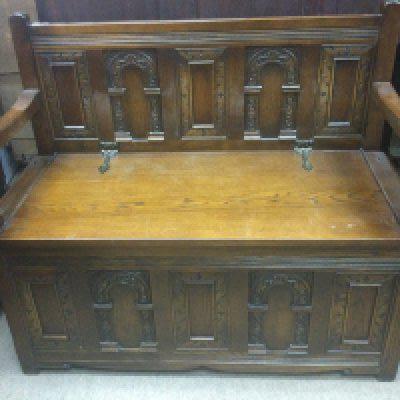 A oaks monks bench the carved back above a lift up seat