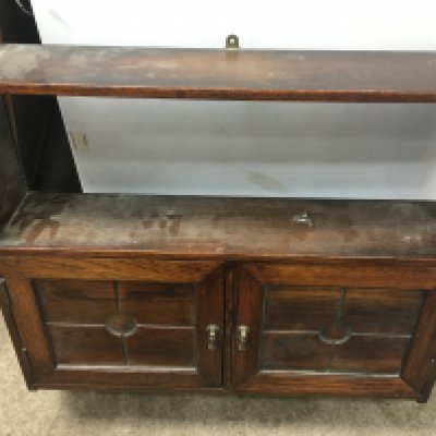 A oak hanging wall cabinet fitted with a pair of paneled doors . NO RESERVE