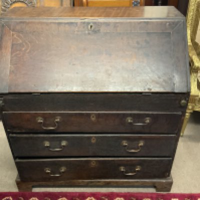 An antique oak Bureau, the fall front enclosing pigeonhole and drawer interior, above four long graduated drawers and raised on bracket feet. 90cm x 100cm
