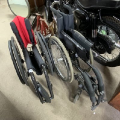 A Carbon Fibre Kuschsall wheelchair together with an additional wheelchair.