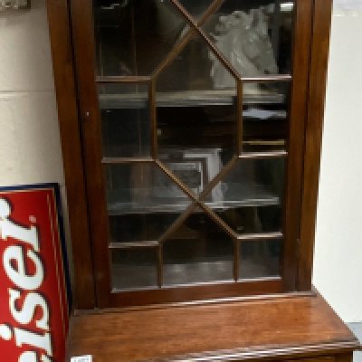A small mahogany cabinet the top with a glazed door above a drawer and cupboard. 60cm wide height 189cm