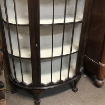 A mahogany semi circular display cabinet on ball and claw feet. 140cm x 138cm