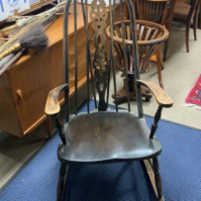 A vintage oak dark stained wheel back rocking chair.