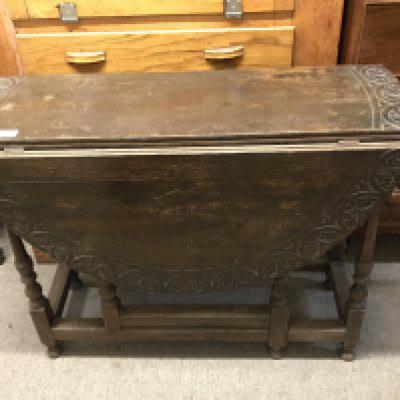 A carved oak drop leaf circular table. No Reserve.