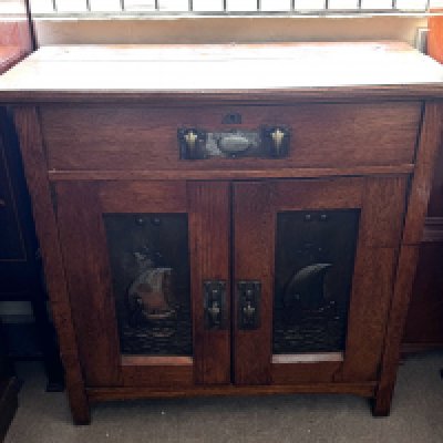 Arts and Crafts oak cabinet made brass fittings and inset pressed panels. 106cm x 102cm x 51cm