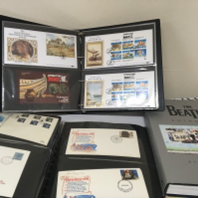 A box containing well presented first day covers in albums the Beatles Anthology and other books