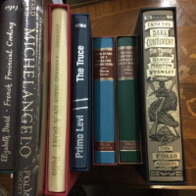 A box containing various books including folio Society .