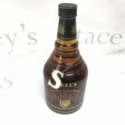 A bottle of bells 21 year old rare scotch whiskey with a silver label.