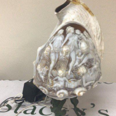 A quality Carved Cameo Conch shells on a metal stand. The shell carved with neo-classical female figure with raised masks. Total hight including stand 28cm. later fitted for electric.
