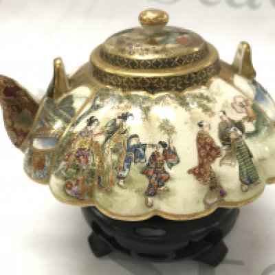 A 19th century Japanese satsuma tea pot decorated with gilt and a figural , temple scene. No damage or restoration . With wooden base. This lot cannot be posted