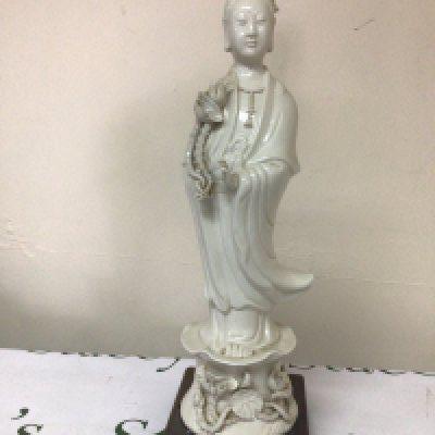 A Chinese porcelain figure Blanc De Chine figure of Guanyin stuck to a hardwood base some damage height 47cm