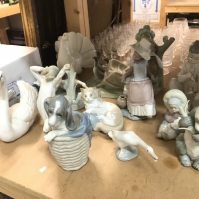 A Collection of Lladro and Nao figures including dog in a basket, dove, girl with geese(damaged) etc. this lot cannot be posted